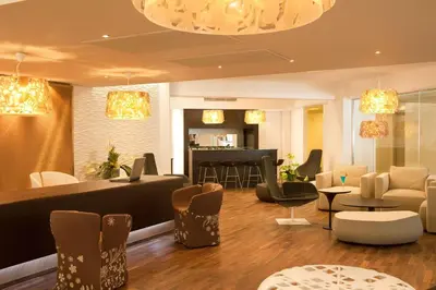 a lobby with a waiting area with chairs and tables at Elysium Resort & Spa in Faliraki