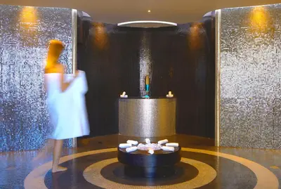 a woman standing in a room with a fountain in a room at Elysium Resort & Spa in Faliraki