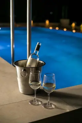 a bottle of wine and two glasses on a table at Blue Sunrise Villa 2 in Afantou