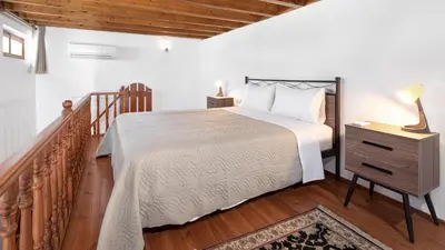 a bedroom with a bed and a night stand with a lamp at Casa Porolithos in Malona Village