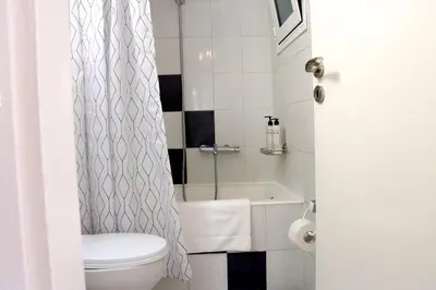 a bathroom with a toilet and a shower curtain at Casa Metropolis in Rhodes Town