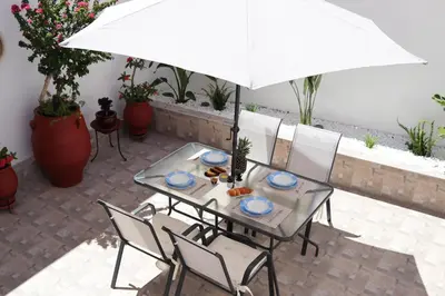 a table and chairs with an umbrella on a patio at Casa Metropolis in Rhodes Town