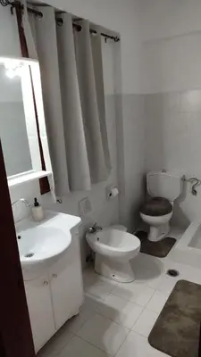 a white bathroom with a toilet and a sink at SteMaMaisonette in Afantou