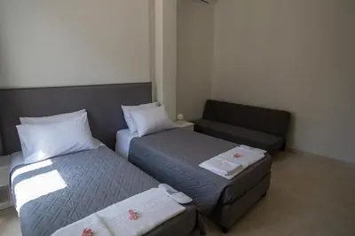 a small room with two beds and a couch at Aegean Sunset Loft in Rhodes Town