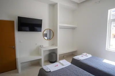 a bedroom with two beds and a mirror and a tv at Aegean Sunset Loft in Rhodes Town