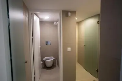 a small bathroom with a toilet and a door at Aegean Sunset Loft in Rhodes Town