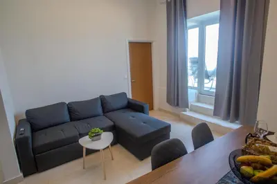 a living room with a blue couch and a table at Aegean Sunset Loft in Rhodes Town