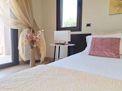 a bedroom with a white bed and a vase with flowers at Villa Maria in Haraki