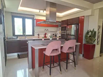 a kitchen with pink stools at a kitchen island at Villa Maria in Haraki