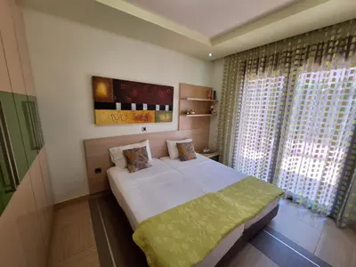 a bedroom with a large white bed and a window at Villa Maria in Haraki