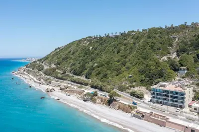a view of a beach with a mountain at Coastal Mirage Sunset Reverie Luxury Seaview Apartment in Rhodes Town
