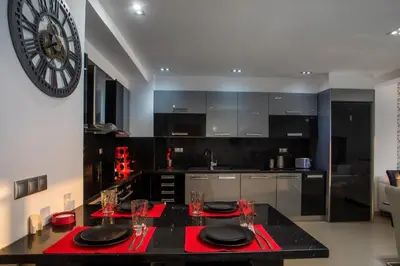 a kitchen with a black counter and a clock on the wall at Coastal Mirage Sunset Reverie Luxury Seaview Apartment in Rhodes Town