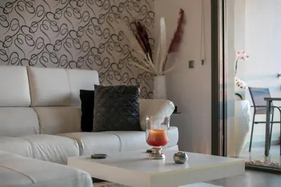 a living room with a white couch and a coffee table at Coastal Mirage Sunset Reverie Luxury Seaview Apartment in Rhodes Town