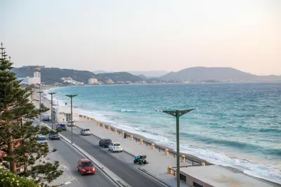 a street with cars parked on a road next to the ocean at Coastal Mirage Sunset Reverie Luxury Seaview Apartment in Rhodes Town