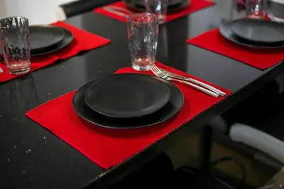 a table with red napkins and black plates and glasses at Coastal Mirage Sunset Reverie Luxury Seaview Apartment in Rhodes Town