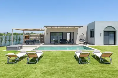 a yard with chairs and a swimming pool at Sunrays Pool Villas in Kalathos