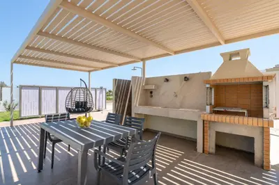 a patio with a table and chairs and a fireplace at Sunrays Pool Villas in Kalathos