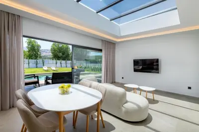 a living room with a white table and chairs at Sunrays Pool Villas in Kalathos