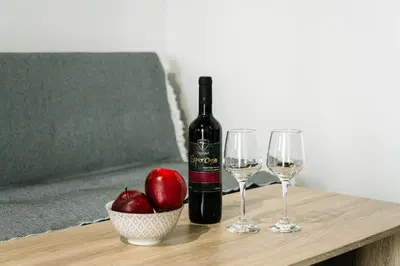 a bottle of wine and two glasses on a table at Rhodes Central Studio by the sea in Rhodes Town