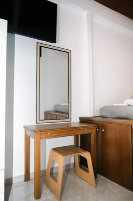 a wooden dressing table with a mirror and a stool at Rhodes Central Studio by the sea in Rhodes Town