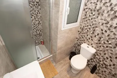 a bathroom with a white toilet and a shower at Steno Loft Suite in Rhodes Town