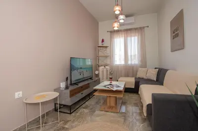 a living room with a couch and a tv at Steno Loft Suite in Rhodes Town