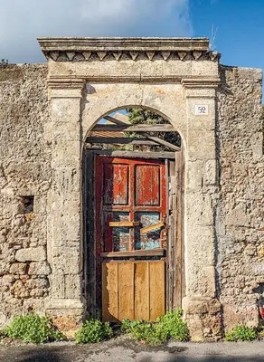 an entrance to a stone building with a red door at Steno Loft Suite in Rhodes Town