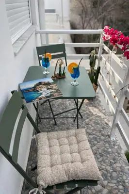 a table and chairs on a balcony with two drinks at Steno Loft Suite in Rhodes Town