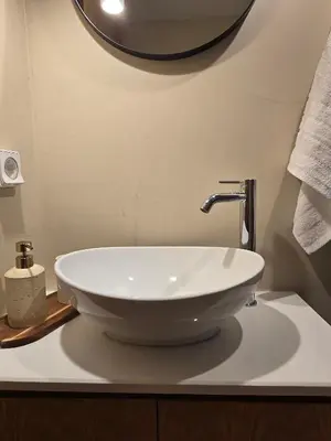 a bathroom with a white sink on a counter at Pension Zoi Luxury Room in Kolimbia