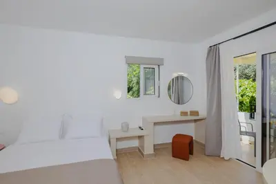 a bedroom with a bed and a desk and a mirror at Pension Zoi Luxury Room in Kolimbia