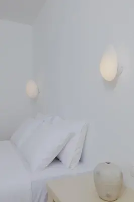 a room with white walls and a table with a vase at Pension Zoi Luxury Room in Kolimbia