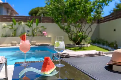 a table with two glasses of watermelon and a plate of watermelons at Ninalma Villa in Kalavárda