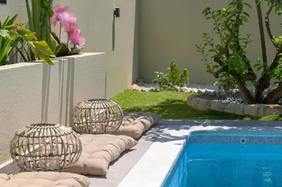 two bird cages next to a swimming pool at Ninalma Villa in Kalavárda