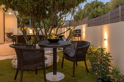 a table with chairs and a bowl of fruit on a patio at Ninalma Villa in Kalavárda