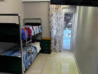 a bedroom with two bunk beds and a sliding door at No Nono in Ialyssos