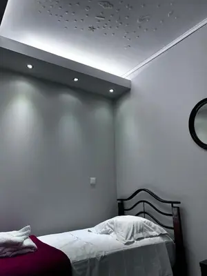 a bedroom with a bed and a white wall at No Nono in Ialyssos