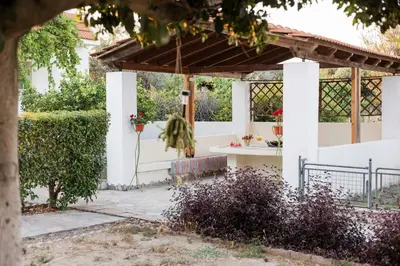 a garden with a pergola and a table at Villa Angelina in Afantou