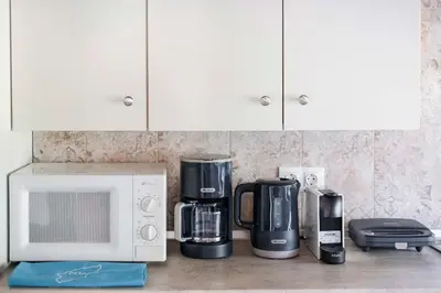 a kitchen counter with a microwave and various appliances at Villa Angelina in Afantou