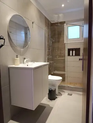 a bathroom with a sink and a toilet and a mirror at Anemomilos View in Koskinou