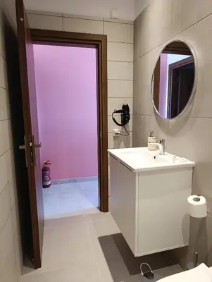 a bathroom with a white sink and a mirror at Anemomilos View in Koskinou