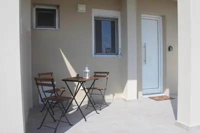 a table and chairs in a room with a window at Anemomilos View in Koskinou