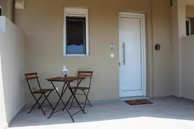 a table and chairs in a room with a door at Anemomilos View in Koskinou