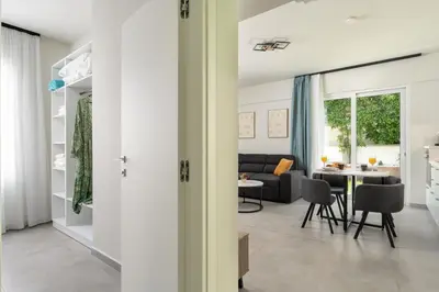 a living room with a couch and a table at Duo Verde Celine Garden Apartment in Kremasti