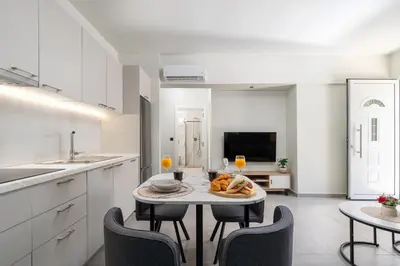 a kitchen with a table with a plate of food on it at Duo Verde Celine Garden Apartment in Kremasti