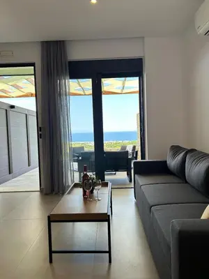 a living room with a couch and a table at Aelios Petra sea view apartment 1 in Asgourou