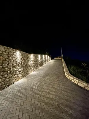 a stone wall with lights on it at night at Aelios Petra sea view apartment 1 in Asgourou