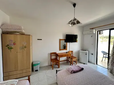a bedroom with a bed and a desk and a table at My Agathi Studios in Haraki