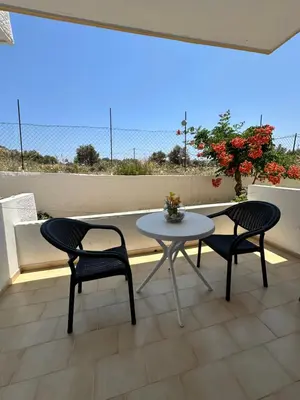 a patio with two chairs and a table on a balcony at My Agathi Studios in Haraki