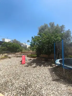 two playground equipment sitting on top of a gravel yard at Villa Agapi in Pastida