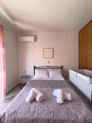 a bedroom with a bed with two towels on it at Villa Agapi in Pastida
